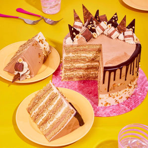 Bueno Cake with 8 hazelnut sponge layers, chocolate ganache drip, Kinder Bueno pieces, and chocolate shards.